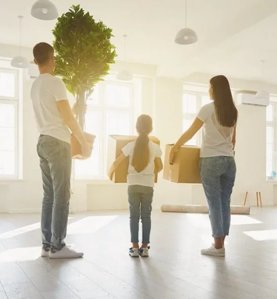 Family carrying boxes into their new home