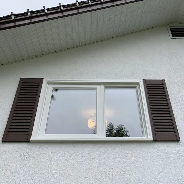 Casement window with shutters on a stucco wall