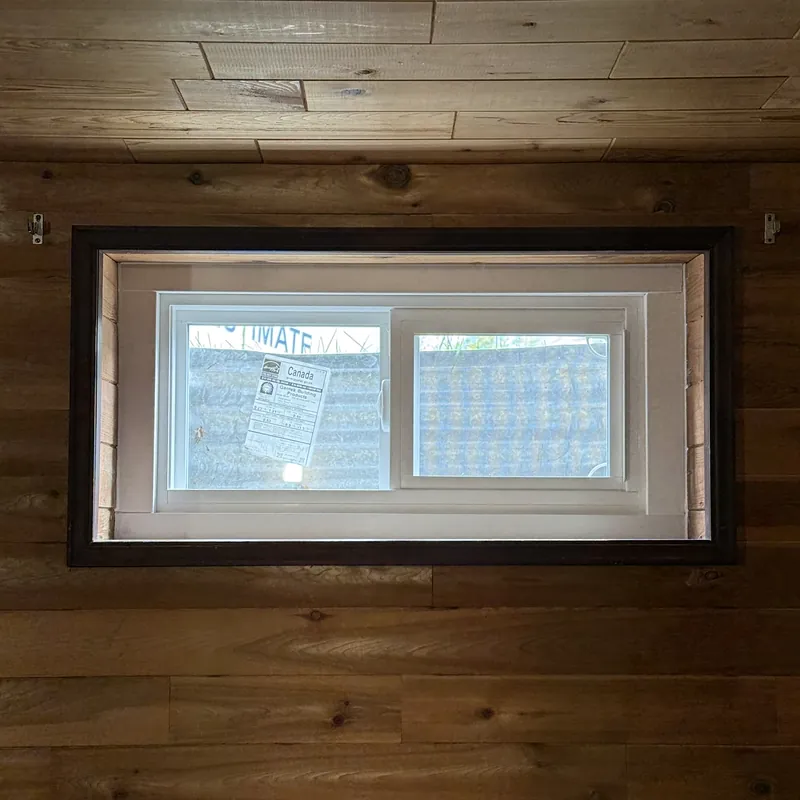 Basement slider window set in a wood-plank wall