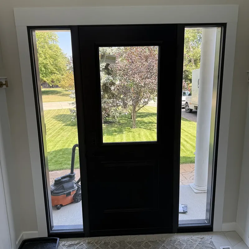 Black front door with two sidelites, seen from inside the entry