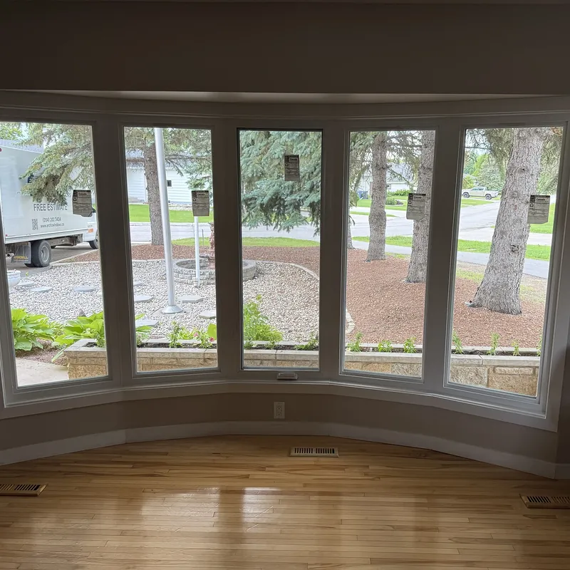 Inside a five-section bow window over a hardwood floor