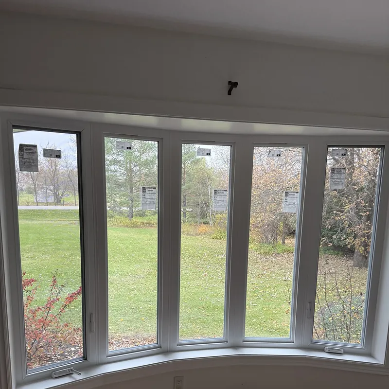 Inside a new five-section bow window, looking out at the lawn