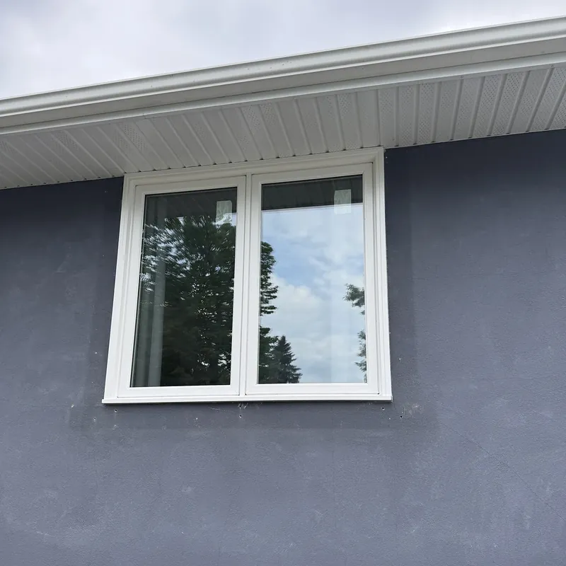Two-section casement window on a navy stucco wall