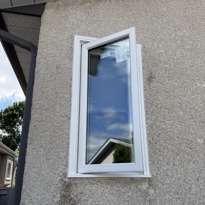 Casement window swung open on a stucco wall