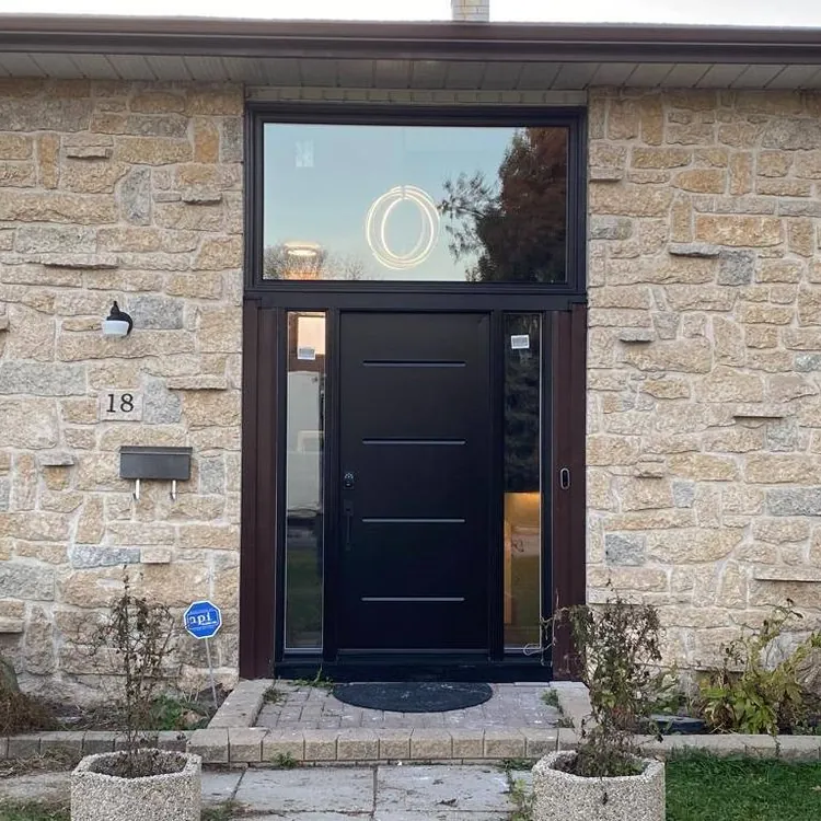Black entry door with sidelite on a stone home