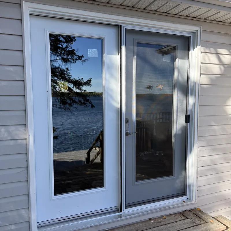 Hinged garden door with a screen, opening onto a deck by the lake