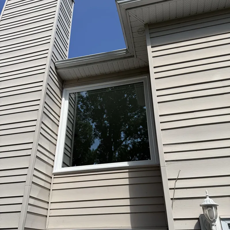 Large window high on a two-storey wall, under a blue sky