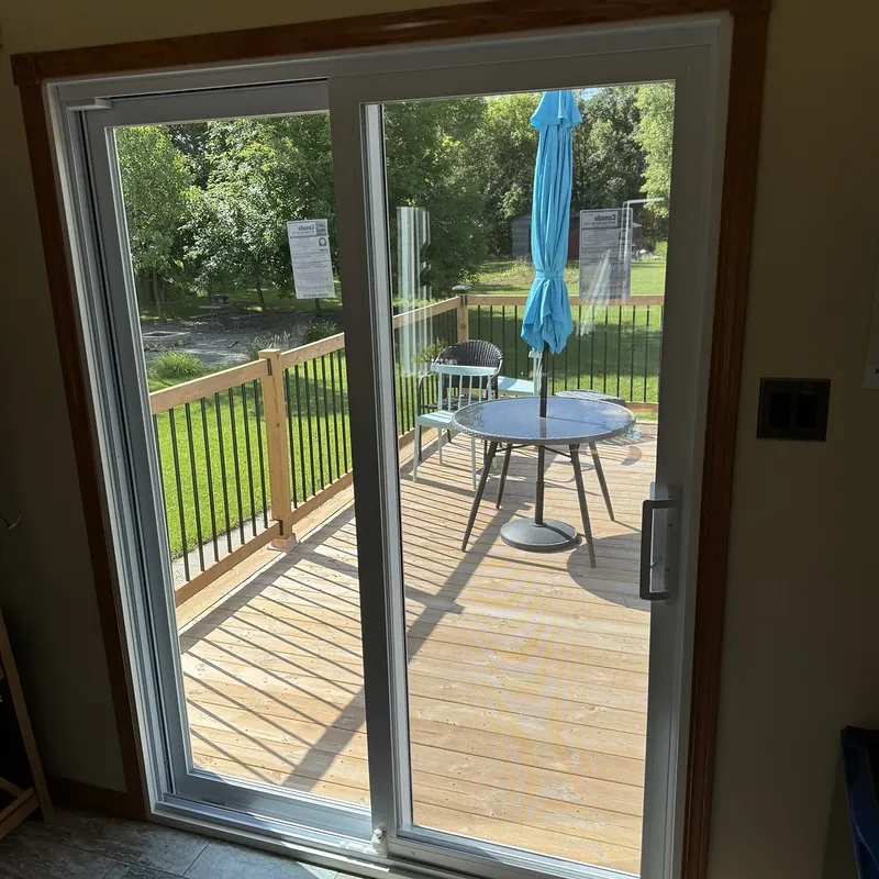 Sliding patio door seen from inside, looking out to a wood deck