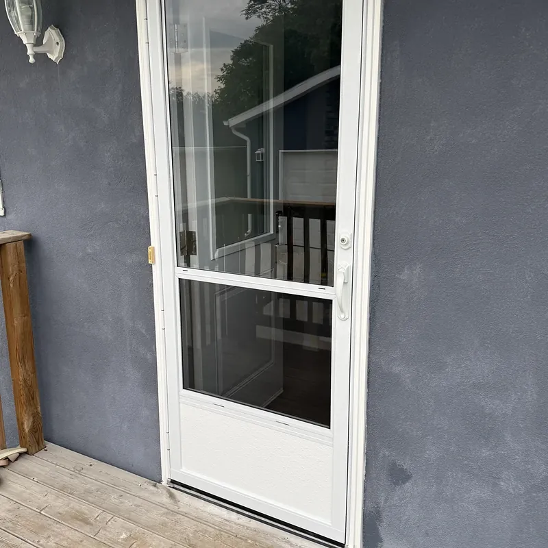 White storm door on a navy stucco wall