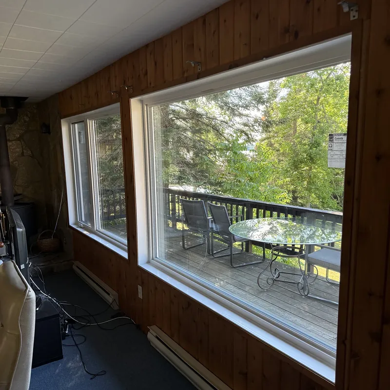 Sunroom with large picture windows looking out to the deck