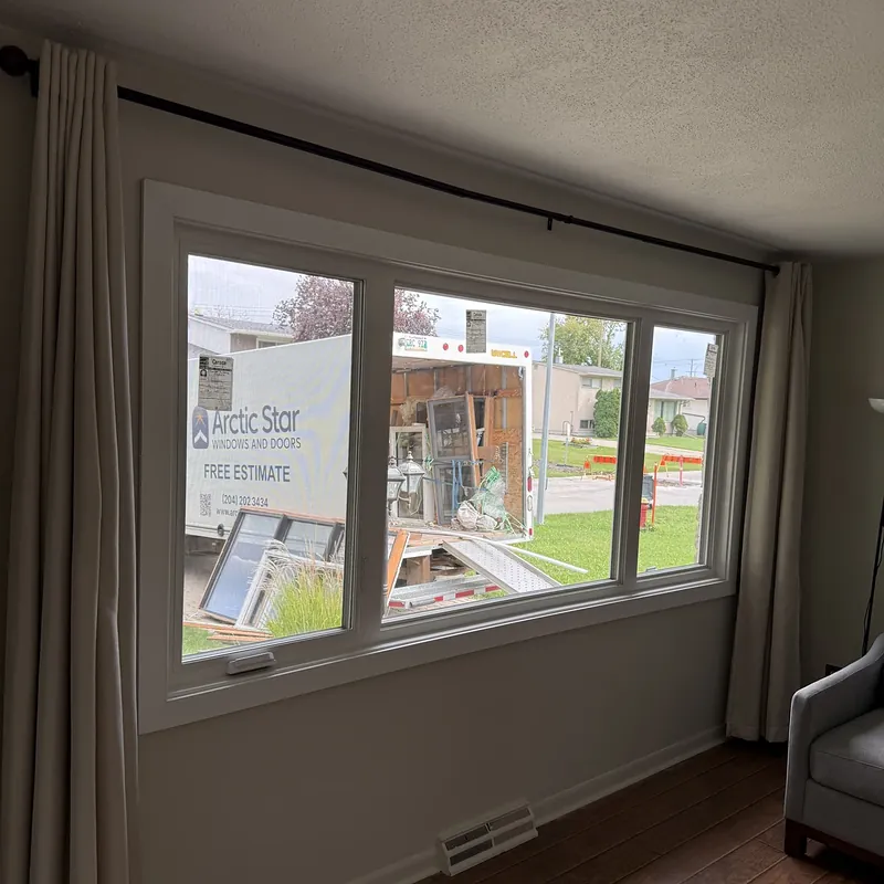 Three-section window seen from inside, with the Arctic Star truck and old windows outside