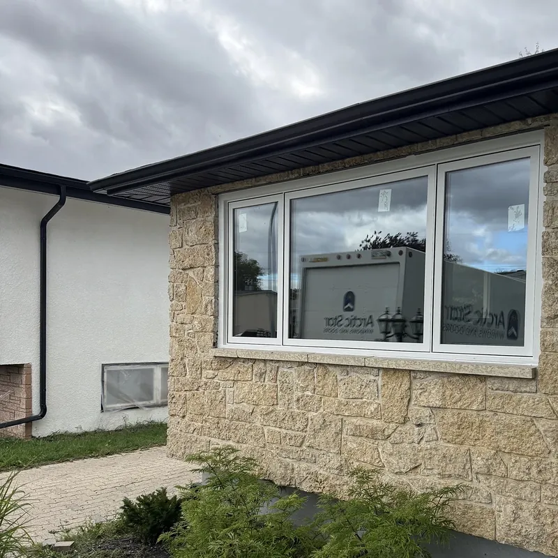 Stone-faced bungalow with a new three-section front window