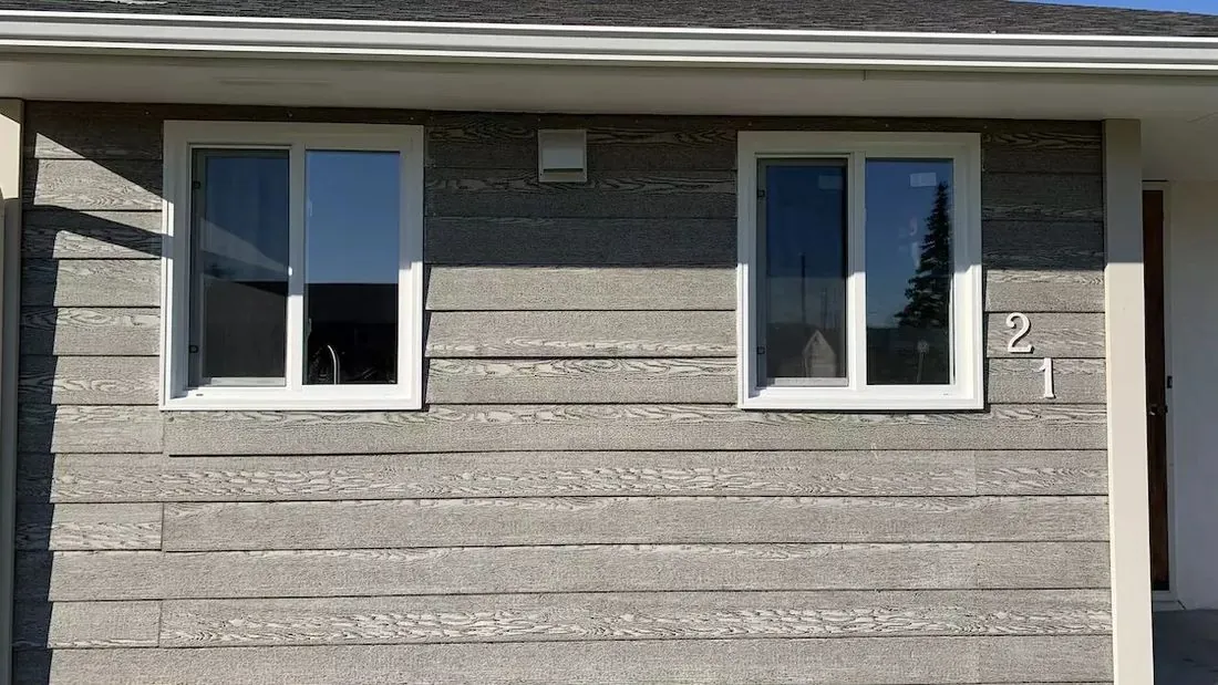 Two slider windows on grey siding