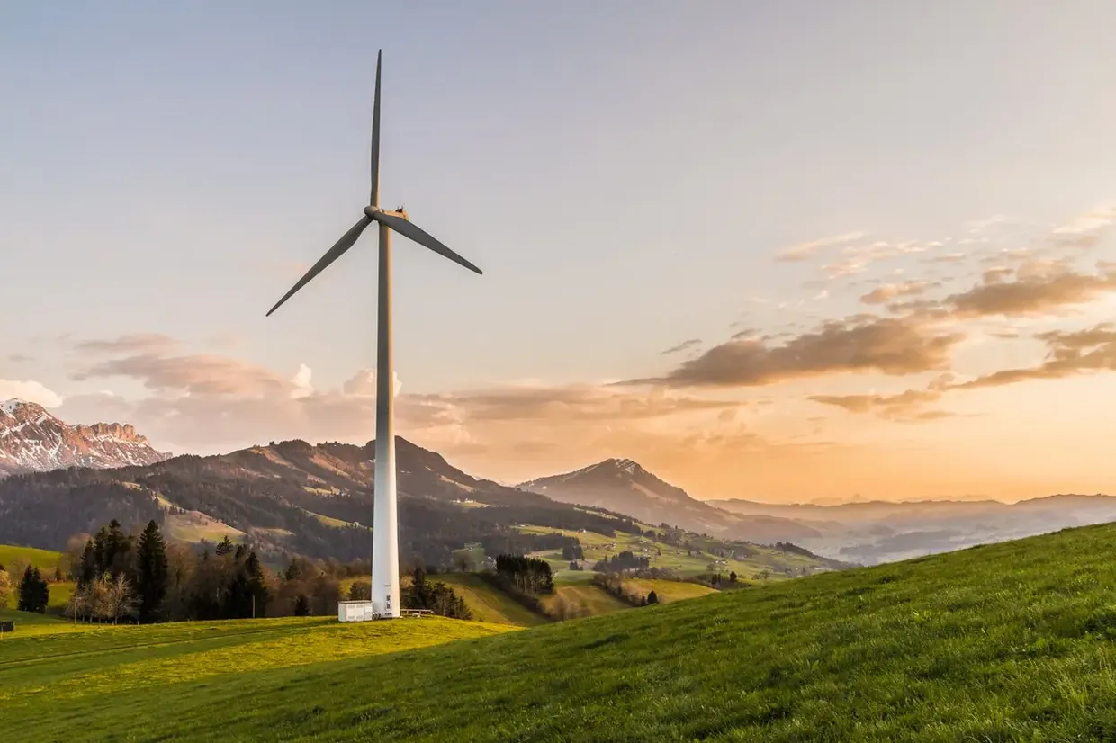 Wind turbine on a hillside at sunset