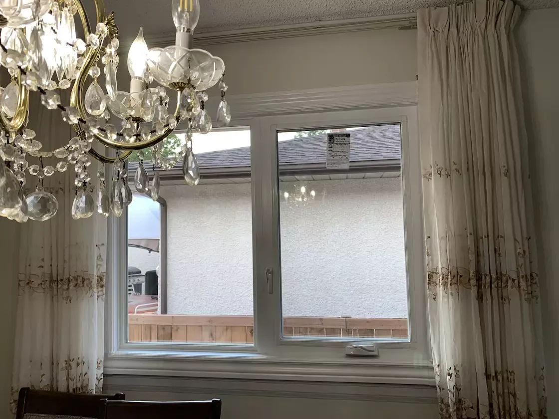 A new casement and picture window seen from inside, with the curtains drawn back and the labels still on the glass