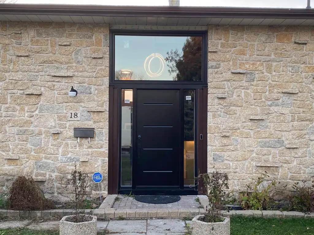 Black solid wood entry door installed in Winnipeg by Arctic Star Windows in 2026
